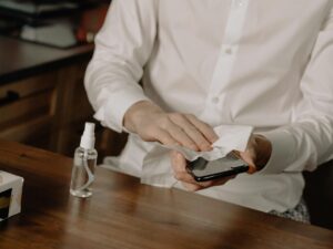person in white dress shirt holding black smartphone