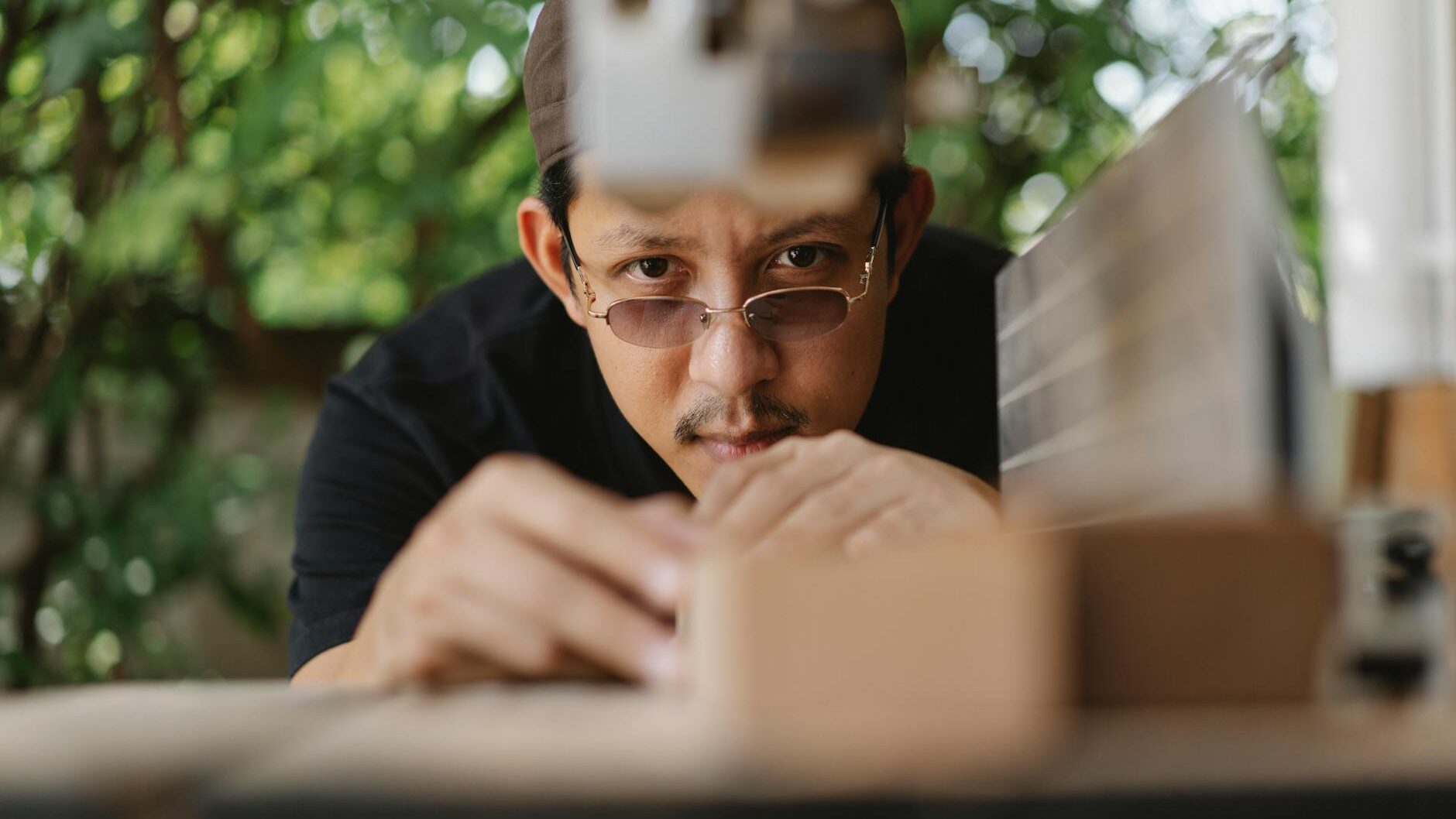serious asian man working with wood outside